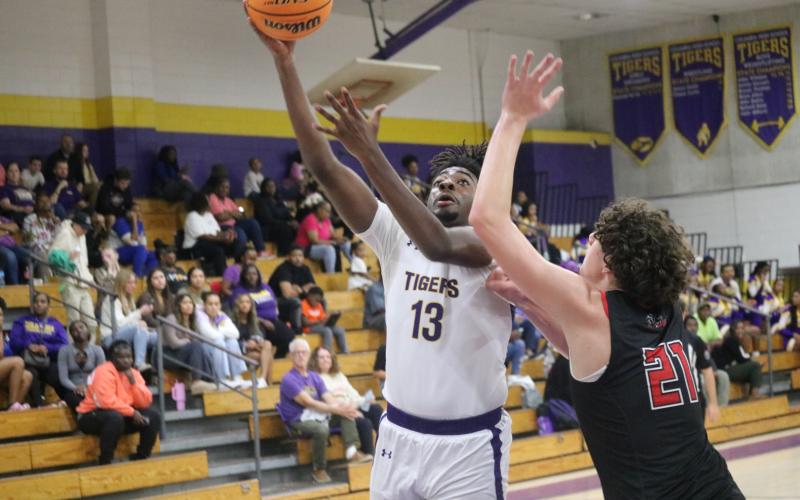 Columbia forward Zavian Douglas scores while defended by The Rock forward Hendrix Loughridge on Tuesday night. (JORDAN KROEGER/Lake City Reporter)