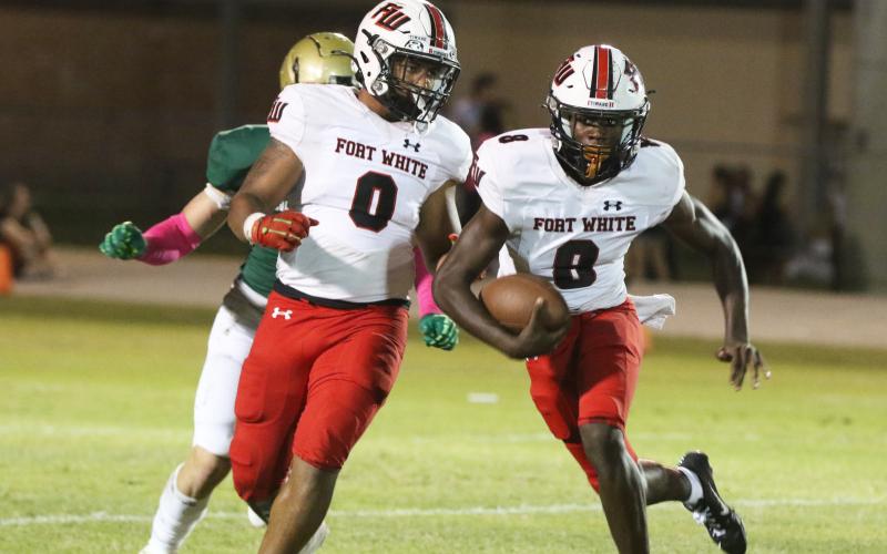 Fort White quarterback Jayden Jackson (8) scrambles up the field alongside running back Lecosta Byrd (0) against Fleming Island on Nov. 1. (MORGAN MCMULLEN/Lake City Reporter)