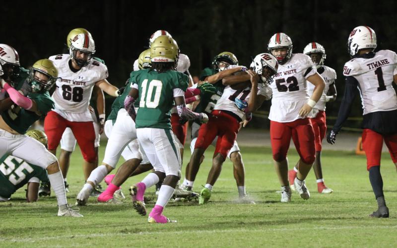 Fort White quarterback Gavin Peterson is dragged backward on a scramble attempt Friday night at Fleming Island. (MORGAN MCMULLEN/Lake City Reporter)