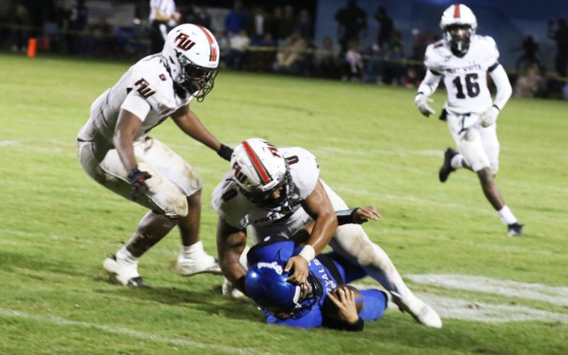 Fort White linebackers Lecosta Byrd (0) and Darion Brinson collapse on Jay quarterback Hayden Morris during last week’s Class Rural playoff game. (MORGAN MCMULLEN/Lake City Reporter)