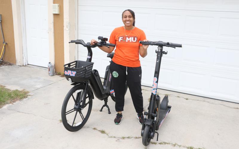 Erica Mayo shows off the e-Fly bike and scooter models that will be used in her upcoming rental business that’ll debut in downtown Lake City in late December. (MORGAN MCMULLEN/Lake City Reporter)