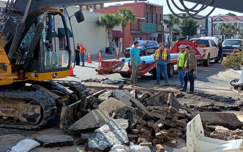 A construction crew takes in the scene above a  ruptured water main in downtown Live Oak. (ROB WOLFE/Lake City Reporter)
