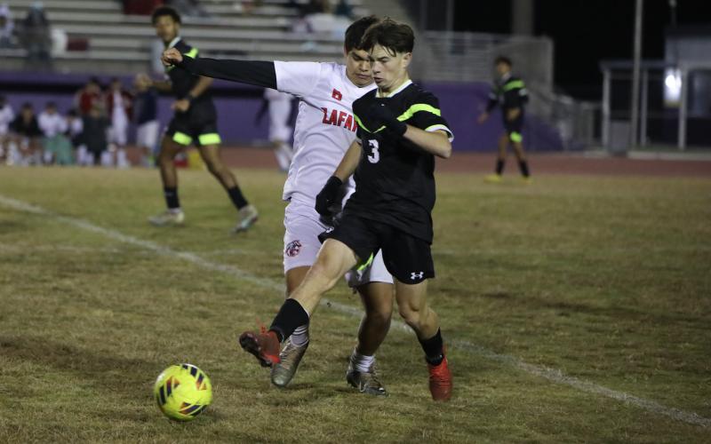 Columbia's Cody Bass passes while defended by Lafayette's Emiliano Tovar on Monday night. (BRENT KUYKENDALL/Lake City Reporter)