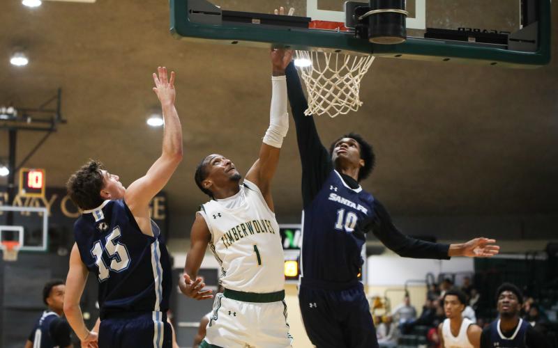 FGC guard Omar'ion Brown drives between Santa Fe guard Ryan Webster (15) and Santa Fe forward Keylson Turner (10) for a layup on Thursday night. (BRENT KUYKENDALL/Lake City Reporter)