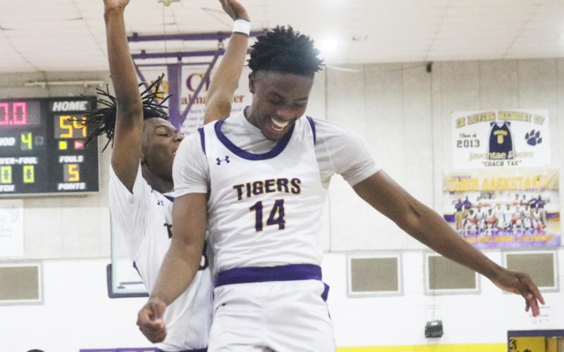Columbia guard Gavin Broomfield (left) and forward Xavier Collins (14) celebrate after the Tigers rallied from a 13-point deficit to defeat Buchholz 54-49 on Tuesday night. (JORDAN KROEGER/Lake City Reporter)