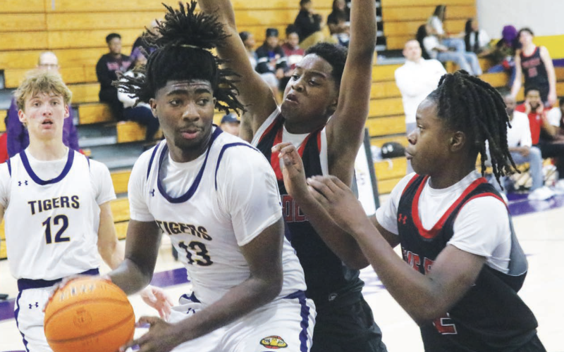 Columbia forward Zavian Douglas looks to pass as he's double teamed by The Rock on Nov. 19. (JORDAN KROEGER/Lake City Reporter)