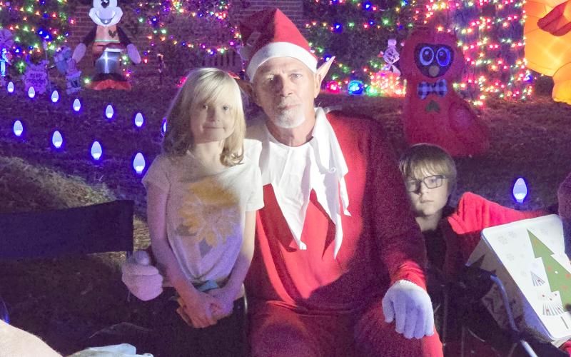 Rocky the Elf is pictured with Evangeline and Rowan McKenna during the special Christmas parade organized for Evangeline, who has been battling cancer for five years. (MONJA SLATER/Lake City Reporter)