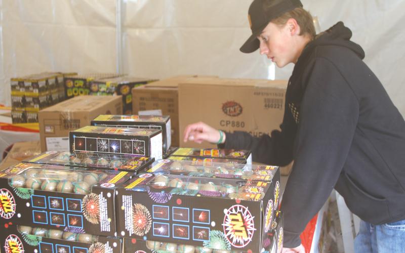Landon Harper conducts an inventory count on fireworks at the Columbia FFA program’s  fireworks tent. (TONY BRITT/Lake City Reporter)