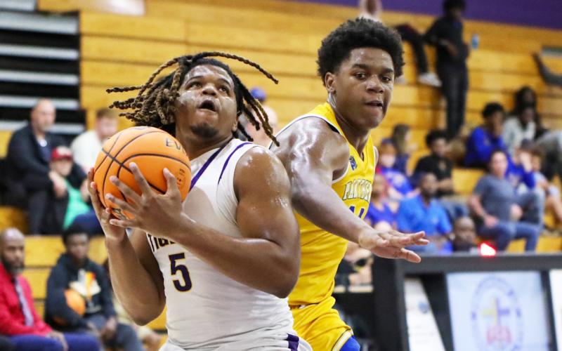 Columbia forward Jalen Gaskins spins past Palatka forward Justin Fells for a layup on Wednesday night. (BRENT KUYKENDALL/Lake City Reporter)