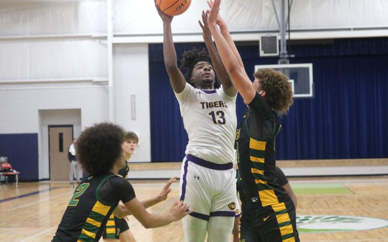 Columbia forward Zavian Douglas shoots over Forest forward Isaac Timmons during the Hitchcock’s Challenge championship on Sunday. (JORDAN KROEGER/Lake City Reporter)
