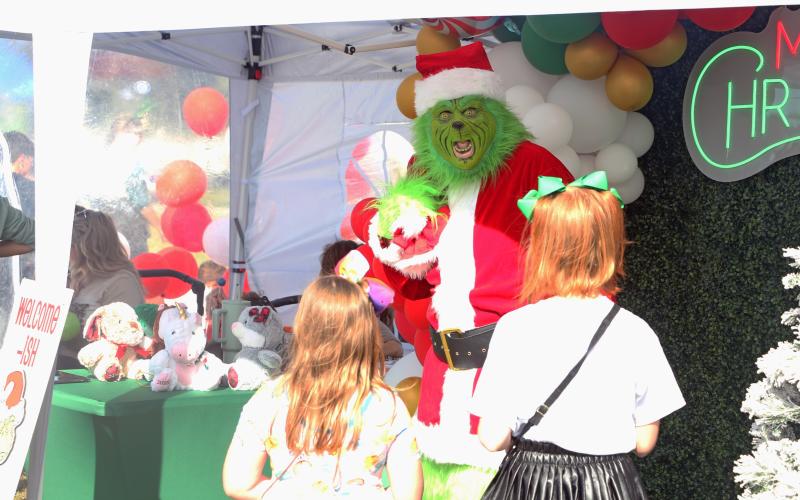 The Grinch speaks with a pair of girls at last year’s Christmas in Columbia Holiday Market. (FILE)