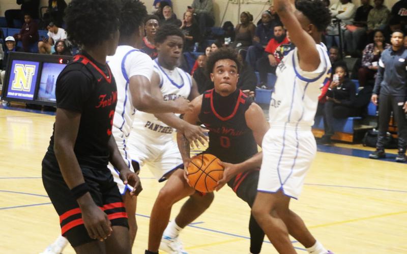 Fort White guard Tafari Moe is bracketed by Newberry defenders during Friday’s 59-45 loss. (MORGAN MCMULLEN/Lake City Reporter)