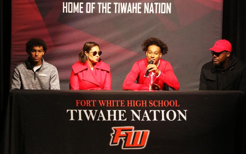 Fort White receiver Mike Peterson Jr. (middle left) speaks during his signing ceremony Wednesday alongside his brother, Gavin (left) mother, Chantal (middle right), and his father, Mike (right). Peterson signed his letter of intent to play collegiately at Arkansas State. (MORGAN MCMULLEN/Lake City Reporter)