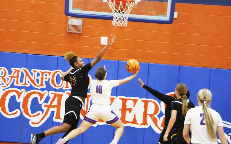 Columbia forward Dariyan Williams goes for a block against Branford guard Cloey Criggall during Monday’s game. (MORGAN MCMULLEN/Lake City Reporter)