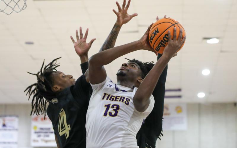 Columbia forward rises to shoot between a pair of Oakleaf defenders on Dec. 6. (BRENT KUYKENDALL/Lake City Reporter)