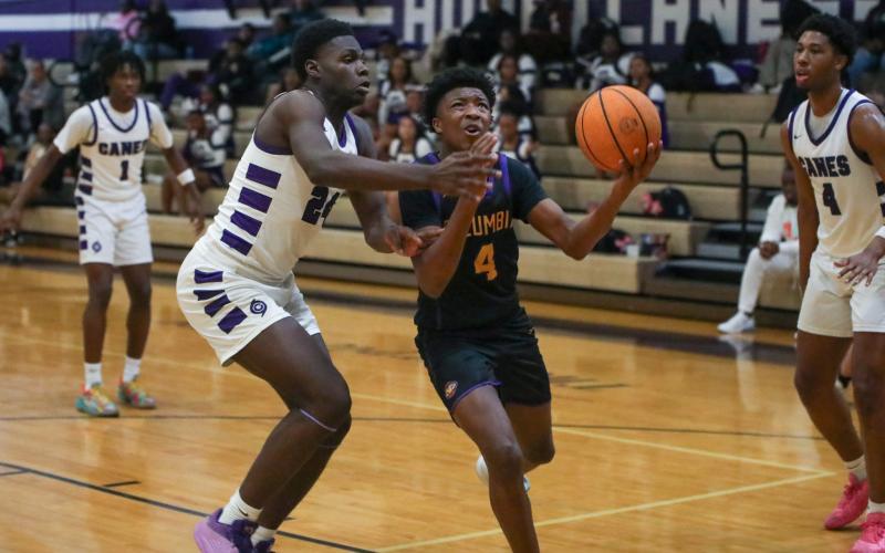 Columbia guard Shaheed White drives to the basket while defended by Gainesville forward David Osho on Thursday. (BRENT KUYKENDALL/Lake City Reporter)
