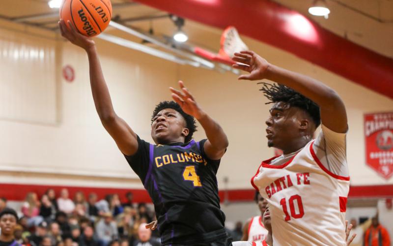 Columbia guard Shaheed White drives past Santa Fe forward Kewan Hall for a layup on Friday night. (BRENT KUYKENDALL/Lake City Reporter)