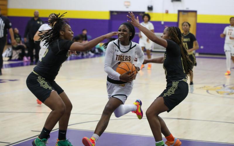 Columbia guard Ayesha Broxey drives to the basket while defended by a pair of Oakleaf players on Tuesday night. (BRENT KUYKENDALL/Lake City Reporter)