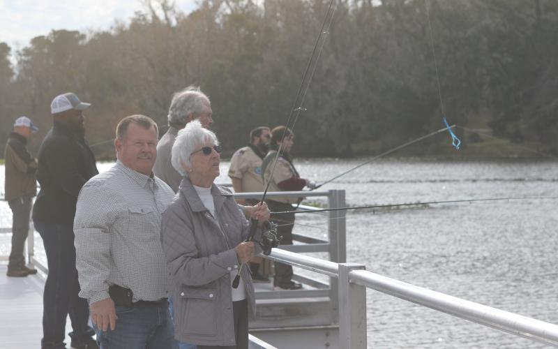 Columbia County Commission Chairman Tim Murphy assists Rose Pavey in casting her line off the new Harter Pier at Lake Montgomery on Friday afternoon. The pier officially opened Friday during a ribbon cutting ceremony. (TONY BRITT/Lake City Reporter)