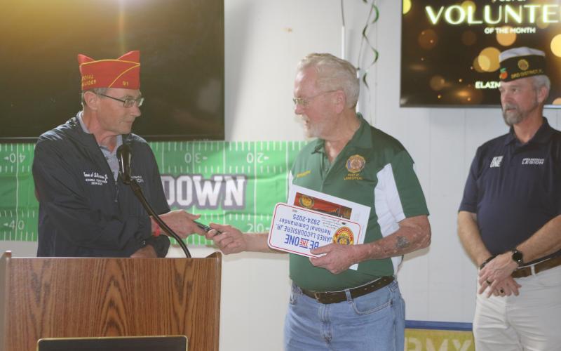William ‘Bill’ Huggins, American Legion Post 57 Commander, receives mementos from James A. LaCoursiere, the national commander of the American Legion, during his visit to Post 57 on Monday. (TONY BRITT/Lake City Reporter)