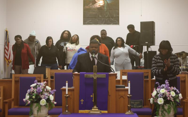 Rev. Jon A. Ingraham, pastor of New Mt. Pisgah AME Church, leads a  prayer during the MLK service on Monday morning. (TONY BRITT/Lake City Reporter)