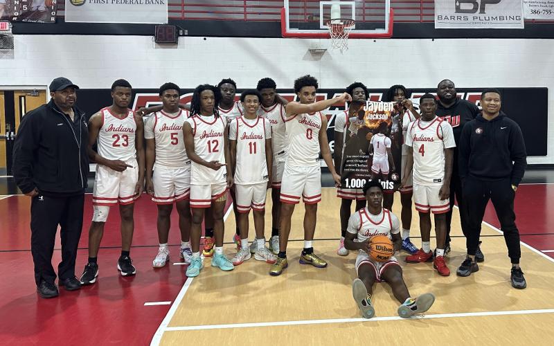 Fort White’s boys basketball team celebrates Jaydan Jackson’s 1,000th career point following Thursday’s win over Bronson. (COURTESY)