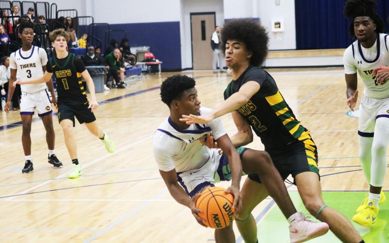 Columbia guard Murkail Cray is fouled by Forest forward Trey Chisolm during the Hitchcock's Challenge championship on Dec. 29. (JORDAN KROEGER/Lake City Reporter)