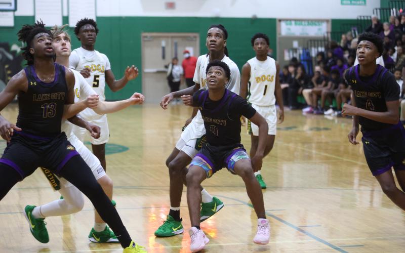 Columbia forward Zavian Douglas (13) and guard Murkail Cray (0) eye a rebound and box out Suwannee while guard Shaheed White (4) also rushes in for a rebound last Friday. (PAUL BUCHANAN/Lake City Reporter)