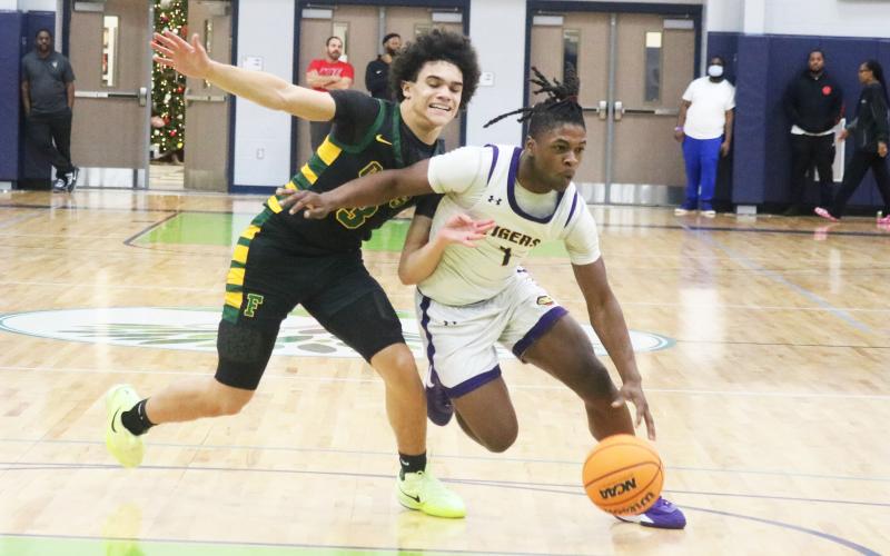 Columbia guard Zamarion Jones dribbles past Forest guard Elijah Leon during the Hitchcock’s Challenge championship on Dec. 29 at Legacy Park in Alachua. (JORDAN KROEGER/Lake City Reporter)