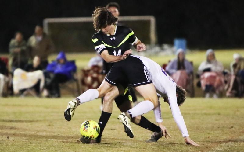 Columbia’s Bobby Shotwell fends off a Gainesville defender while trying to maintain possession of the ball on Jan. 10. (BRENT KUYKENDALL/Lake City Reporter)