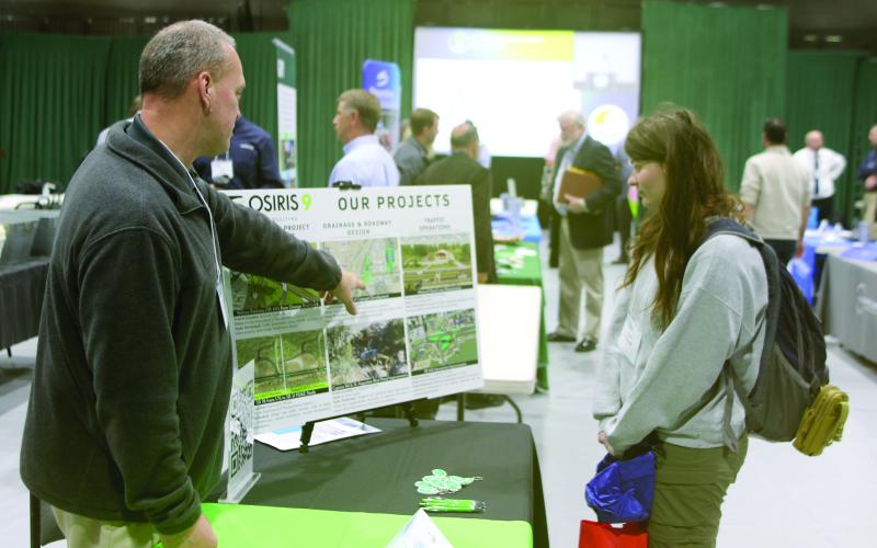 Bryon Wuczynski (left), an Osiris 9 representative, shows a list of recent projects to April Thomas with the Florida Department of Transportation. Osiris 9 helped develop the concept for the U.S. Highway 41 and Interstate 75 interchange project that will be starting soon in Ellisville. (TONY BRITT/Lake City Reporter)