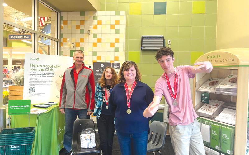 Jeff Wegner (from left), a Special Olympic Athletes Coach at Lake City Christian Academy, stands with athletes Jersey, Donna and Wyatt, after a fundraising session in the Lake City Publix super market. (COURTESY)