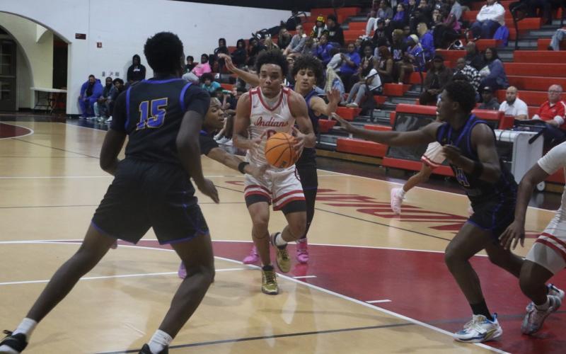 Fort White guard Tafari Moe gets surrounded by four Newberry defenders on his way to the rim in Thursday’s loss. (MORGAN MCMULLEN/Lake City Reporter)