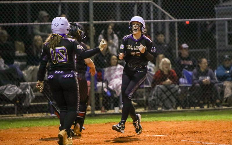 Columbia catcher Emily Delgado celebrates as she scores to tie the game in the fifth inning of Monday's season opener against Fort White. (BRENT KUYKENDALL/Lake City Reporter)