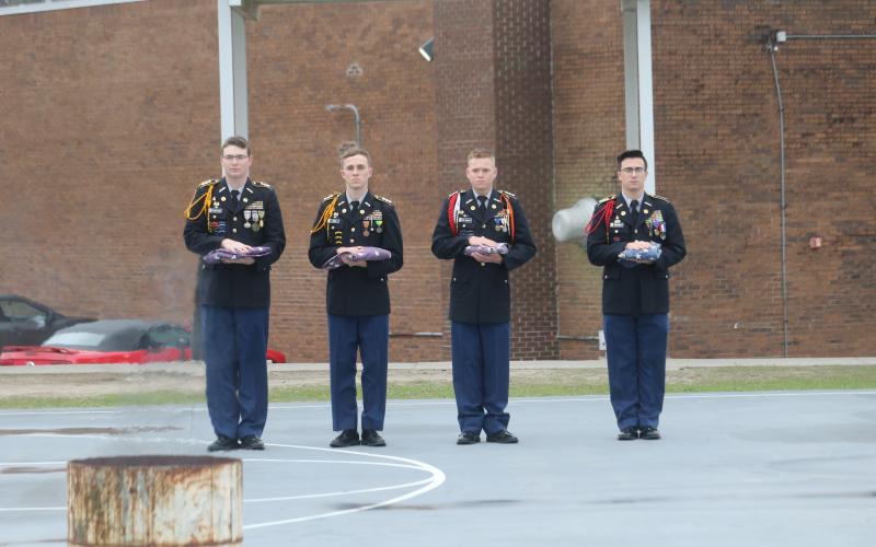 Four Columbia High School JROTC Cadets hold old flags set to be destroyed during the JROTC’s Flag Retirement Service on Thursday morning. (TONY BRITT/Lake City Reporter)