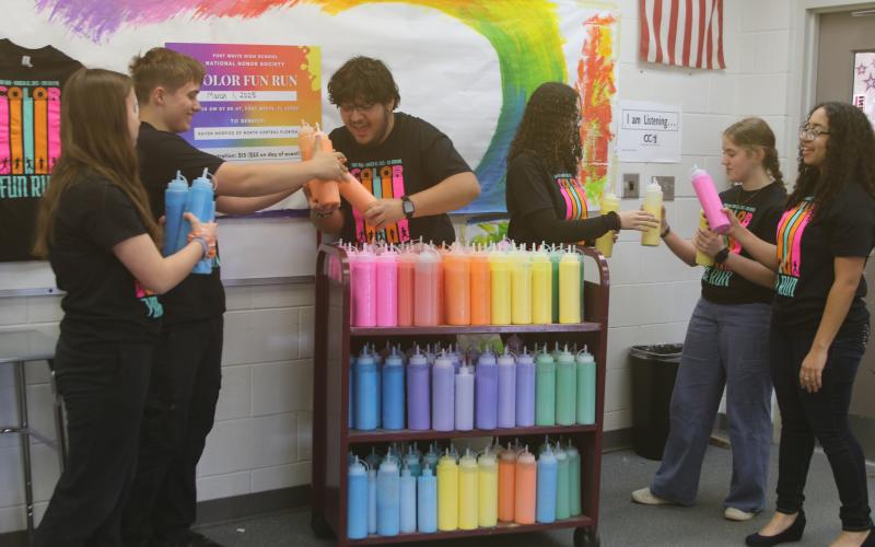 Fort White National Honor Society members Jada Knight (from left), Jack Schroader, Juan Bustamante, Arelis Maldonado, Sarah Heeke and Anais Maldonado prepare and inventory powder for the club’s color fun run which takes place on Saturday at Arrowhead Stadium. (TONY BRITT/Lake City Reporter)