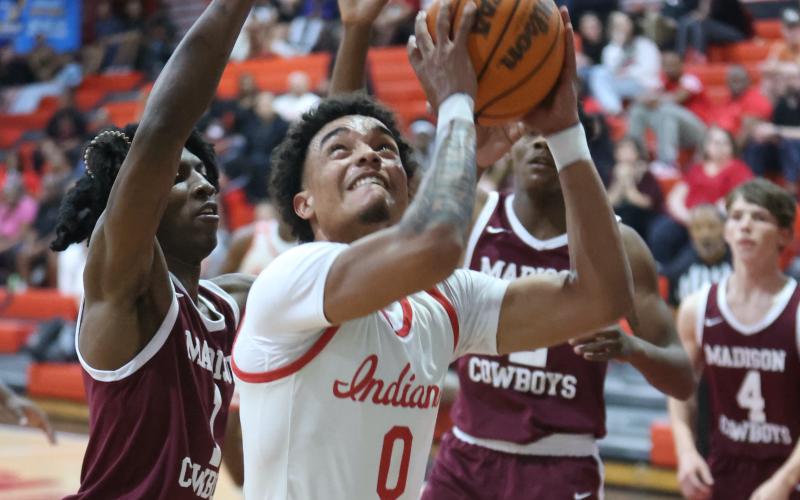 Fort White guard Tafari Moe tries to get off a shot while surrounded by Madison County's defense during Wednesday's Region 3-R semifinal. (PAUL BUCHANAN/Lake City Reporter)