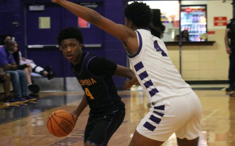 Columbia guard Shaheed White tries to throw pass around Gainesville forward Cornelius White during the Region 1-5A quarterfinals on Wednesday night. (JORDAN KROEGER/Lake City Reporter)