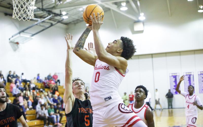 Fort White guard Tafari Moe shoots while defended by Trenton guard Mason VunCannon during the District 6-R championship on Friday. (BRENT KUYKENDALL/Lake City Reporter)
