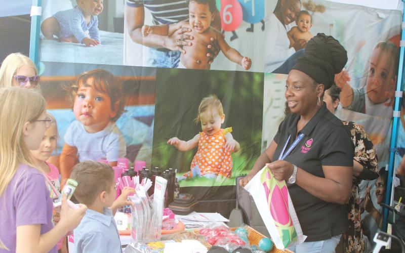 Festivalgoers pick up goodies from the Florida Department of Health’s tent at the Olustee Festival this past weekend. The 46th annual event was a success, including the addition of the Battle of the Bands. (TONY BRITT/Lake City Reporter)