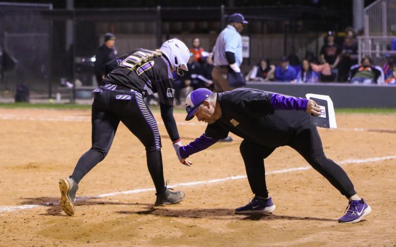 Columbia pitcher Harleigh Prices low fives head coach Joe Saucier as she rounds third base after hitting a 3-run home run against Branford on Monday night. (BRENT KUYKENDALL/Lake City Reporter)
