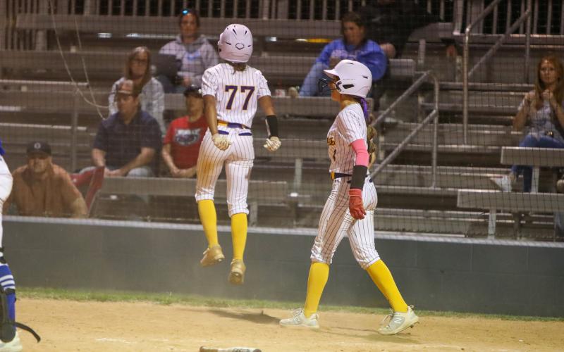 Columbia left fielder Sakiya Merriex jumps after crossing home plate with the game-winning run against Keystone Heights Friday night. Shortstop Lillyenne Mayhew, who had also scored on the play, celebrates alongside Merriex. (BRENT KUYKENDALL/Lake City Reporter)