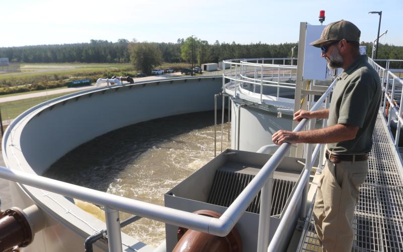 City of Lake City Wastewater Director Cody Pridgeon looks in on a tank of untreated wastewater Wednesday morning at the North Florida Mega Industrial Park wastewater plant, which recently started operations. (TONY BRITT/Lake City Reporter)