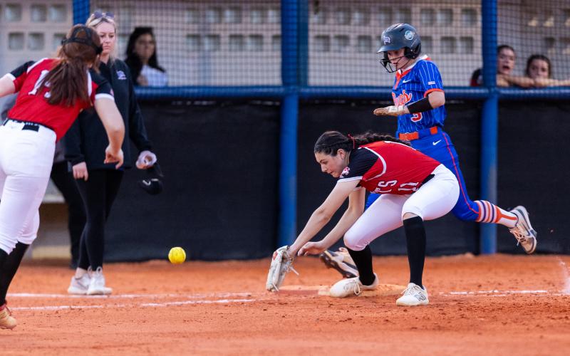 Lafayette second baseman Clara Knight (14) makes a throwing error to allow Branford's Cloey Criggall to reach first base safely Thursday night. (JACK HOWDESHELL/Lake City Reporter)