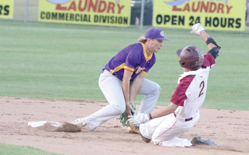 North Marion’s Tucker Jones slides in safely at second base as Columbia shortstop Logan Brooks attempts to field a throw Friday night. (MORGAN MCMULLEN/Lake City Reporter)