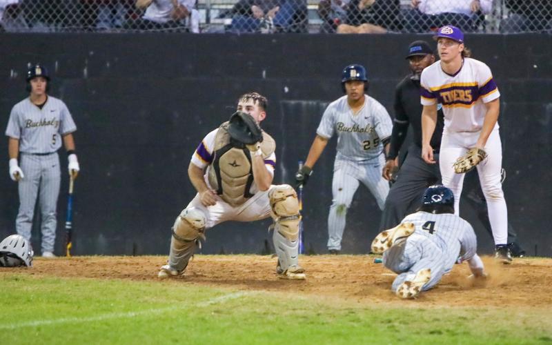 A throw is late to Columbia catcher Casen Maddox as Buchholz shortstop Hudson Sapp slides safely into home plate in front of Columbia pitcher Ayden Phillips on Friday. (BREN KUYKENDALL/Lake City Reporter)