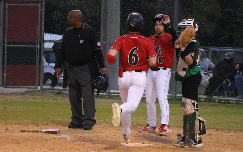Fort White's Matthew Pitts (6) is greeted at home plate by junior Davic Kasper during Monday's 16-1 win over Ocala Christian. (MORGAN MCMULLEN/Lake City Reporter)