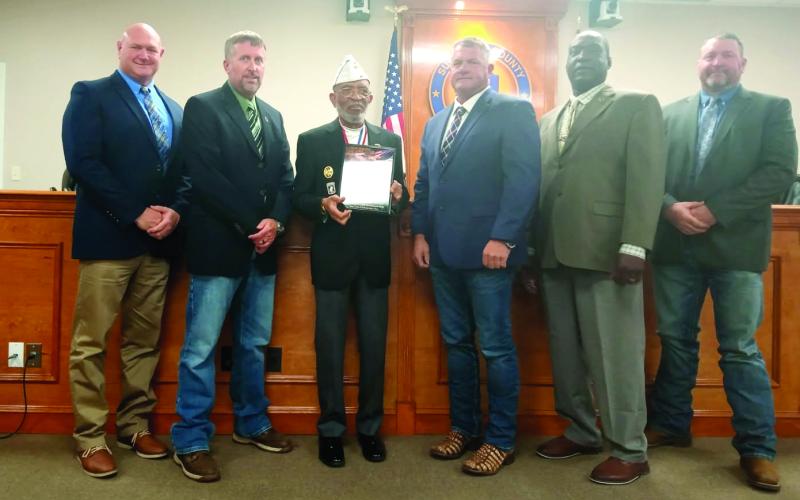 Command Sergeant Major William Smith (third from left) presents a plaque designating Suwannee County as a Purple Heart County to Commissioners Don Hale (from left), Travis Land, Franklin White, Maurice Perkins and Leo Mobley at the board’s March 4 meeting. (COURTESY)