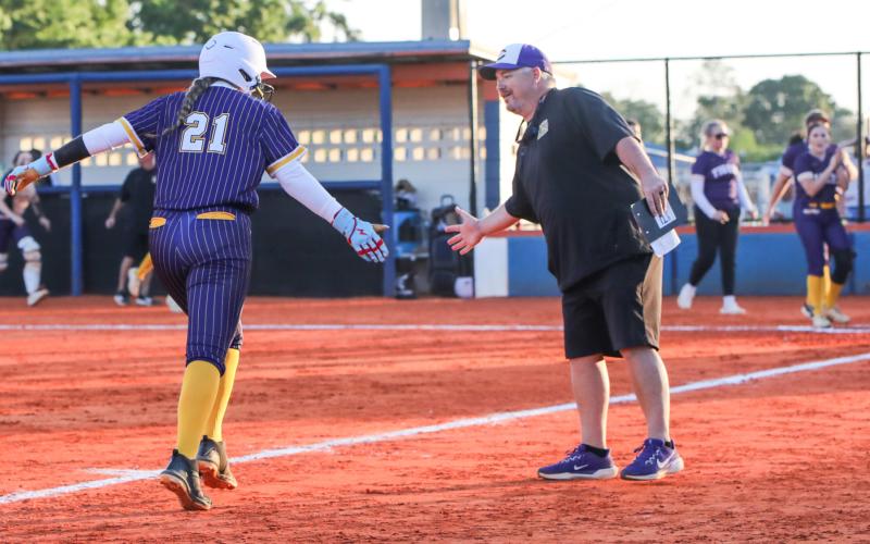 Columbia pitcher Harleigh Price high fives coach Joe Saucier as she rounds third base after hitting a home run against Branford on Tuesday. (BRENT KUYKENDALL/Lake City Reporter)