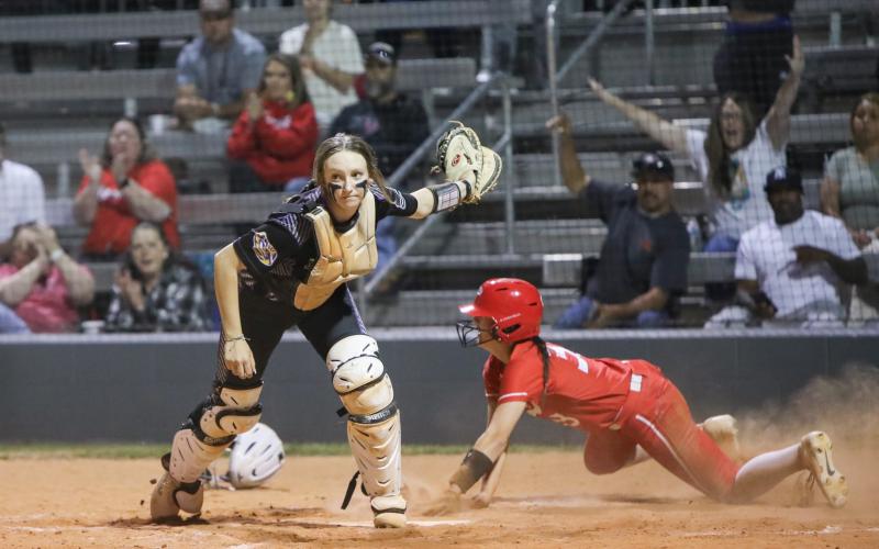 Middleburg third baseman KK Hagan slides under the tag of Columbia catcher Emily Delgado to score the go-ahead run in the seventh inning Thursday. The Broncos scored five runs in the inning to win 8-3. (BRENT KUYKENDALL/Lake City Reporter)